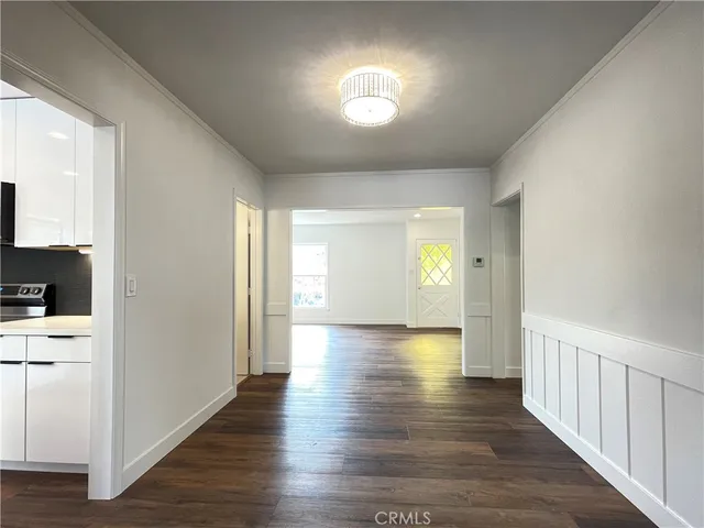 a large kitchen with stainless steel appliances wooden floor and a large window