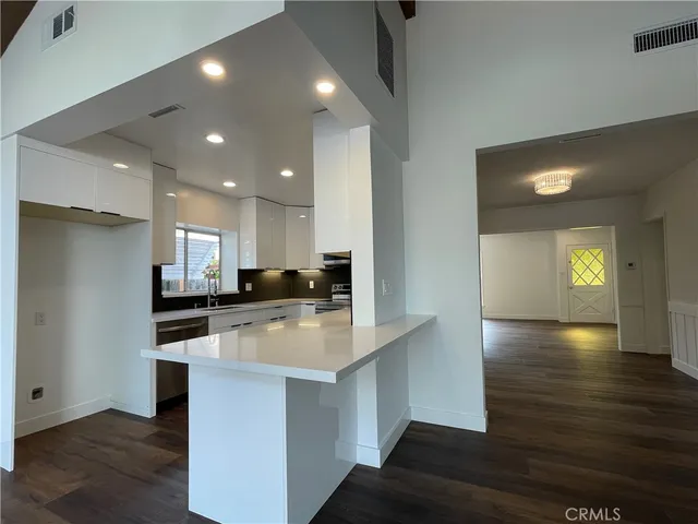 a large kitchen with stainless steel appliances granite countertop a stove a sink and a refrigerator