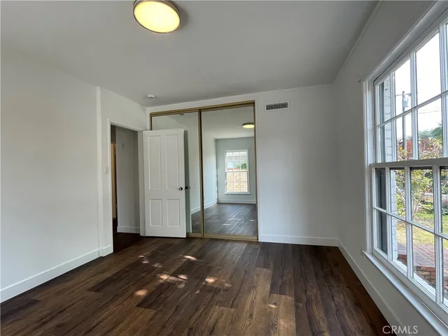 a view of a room with wooden floor and windows