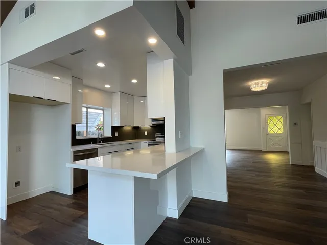 a large kitchen with stainless steel appliances granite countertop a stove a sink and a refrigerator