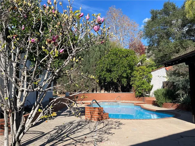 a view of a room with wooden floor ceiling fan and windows