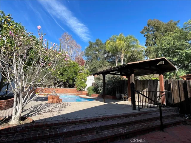 a view of a swimming pool with an outdoor seating and a yard