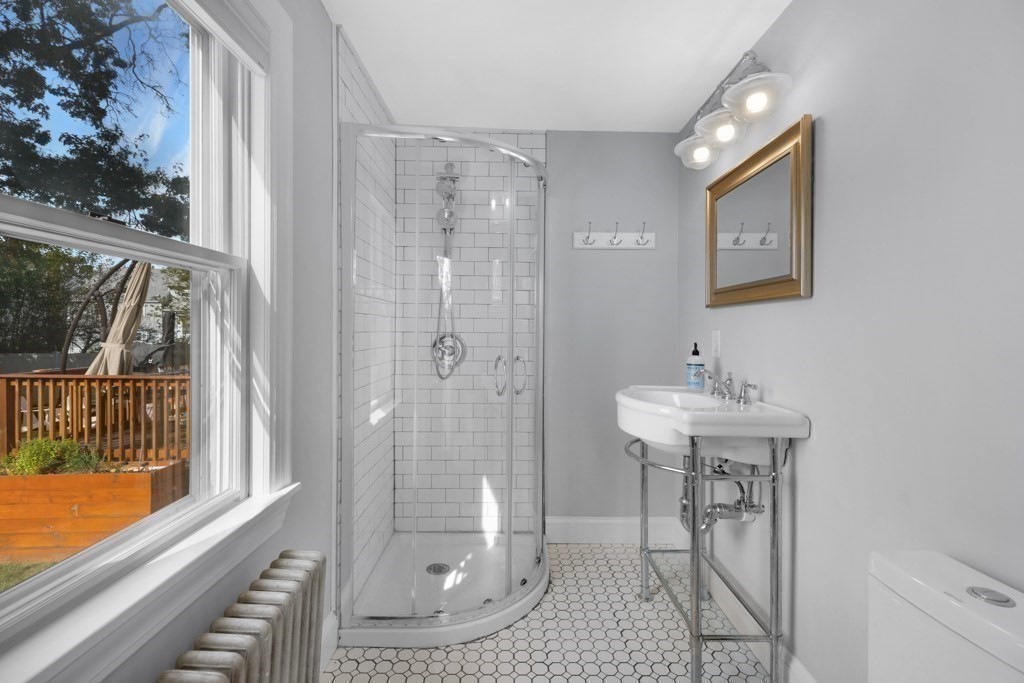 4 Rice Road Quincy, MA 02170 - Photo 14 of 26 a bathroom with a shower a mirror and a sink