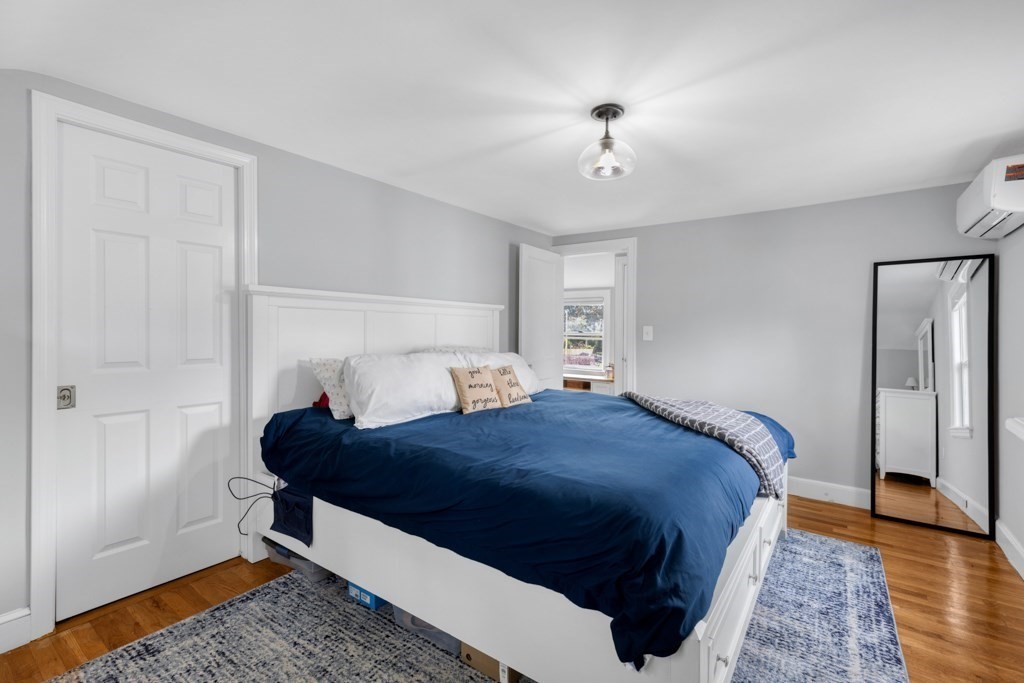 4 Rice Road Quincy, MA 02170 - Photo 18 of 26 a bedroom with a bed lamps and wooden floor