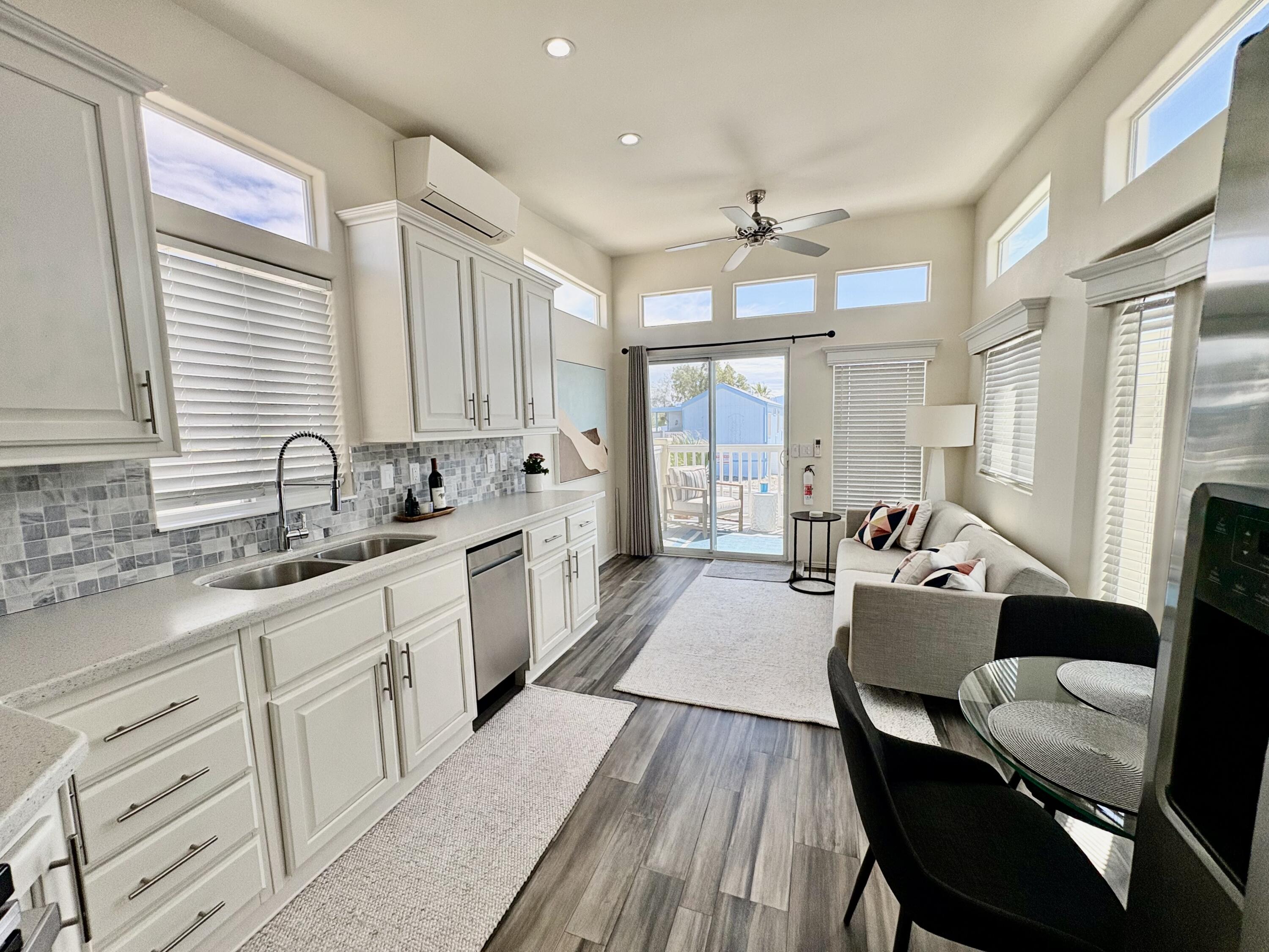 70200 Dillon Road, Unit 200 Desert Hot Springs, CA 92241 - Photo 12 of 31 a large white kitchen with cabinets a sink a window and stainless steel appliances