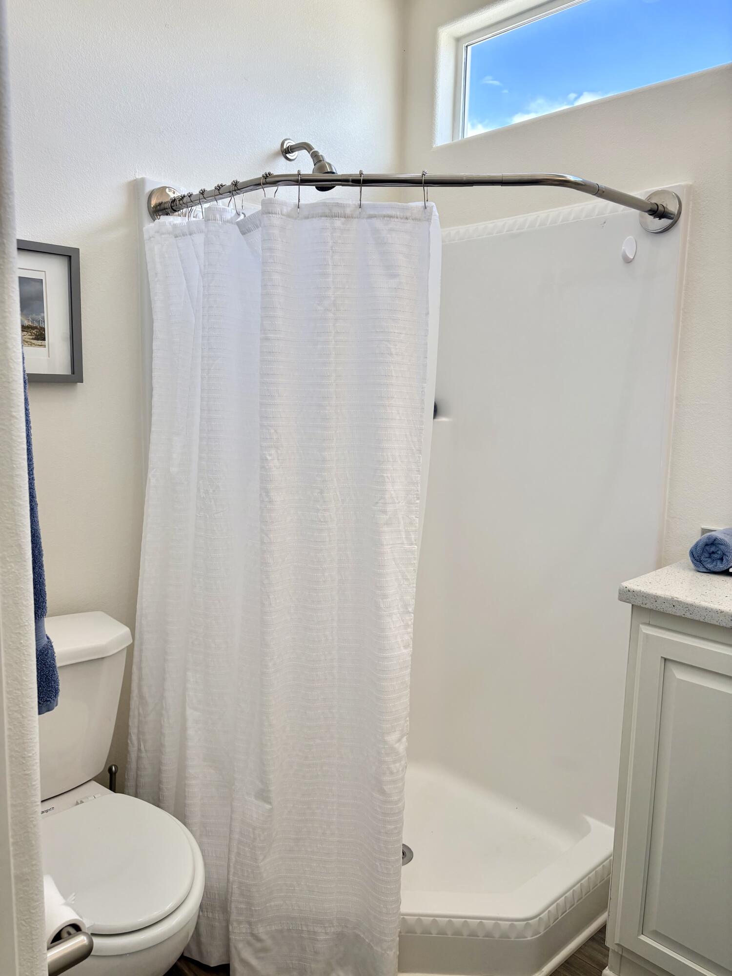 70200 Dillon Road, Unit 200 Desert Hot Springs, CA 92241 - Photo 15 of 31 a white toilet sitting next to a shower curtain
