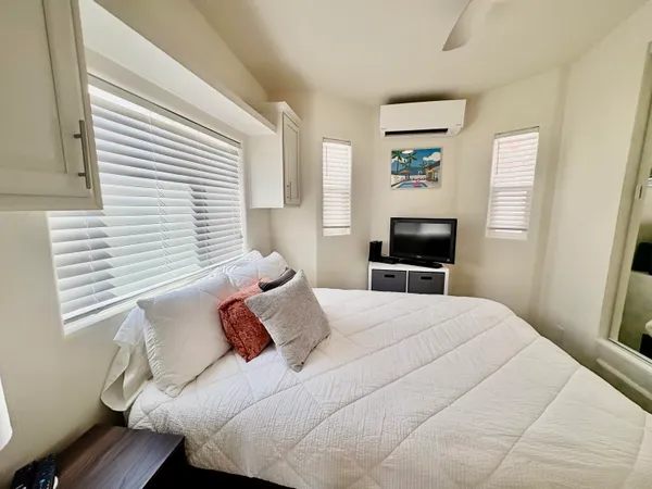 a bedroom with a bed and a flat screen tv