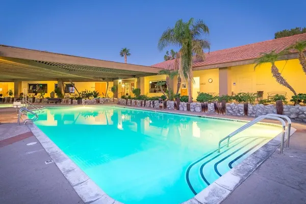 a view of a swimming pool with a lawn chairs and a swimming pool