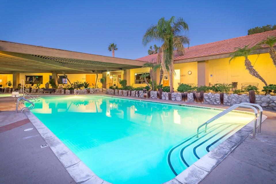 70200 Dillon Road, Unit 200 Desert Hot Springs, CA 92241 - Photo 27 of 31 a view of a swimming pool with a lawn chairs and a swimming pool