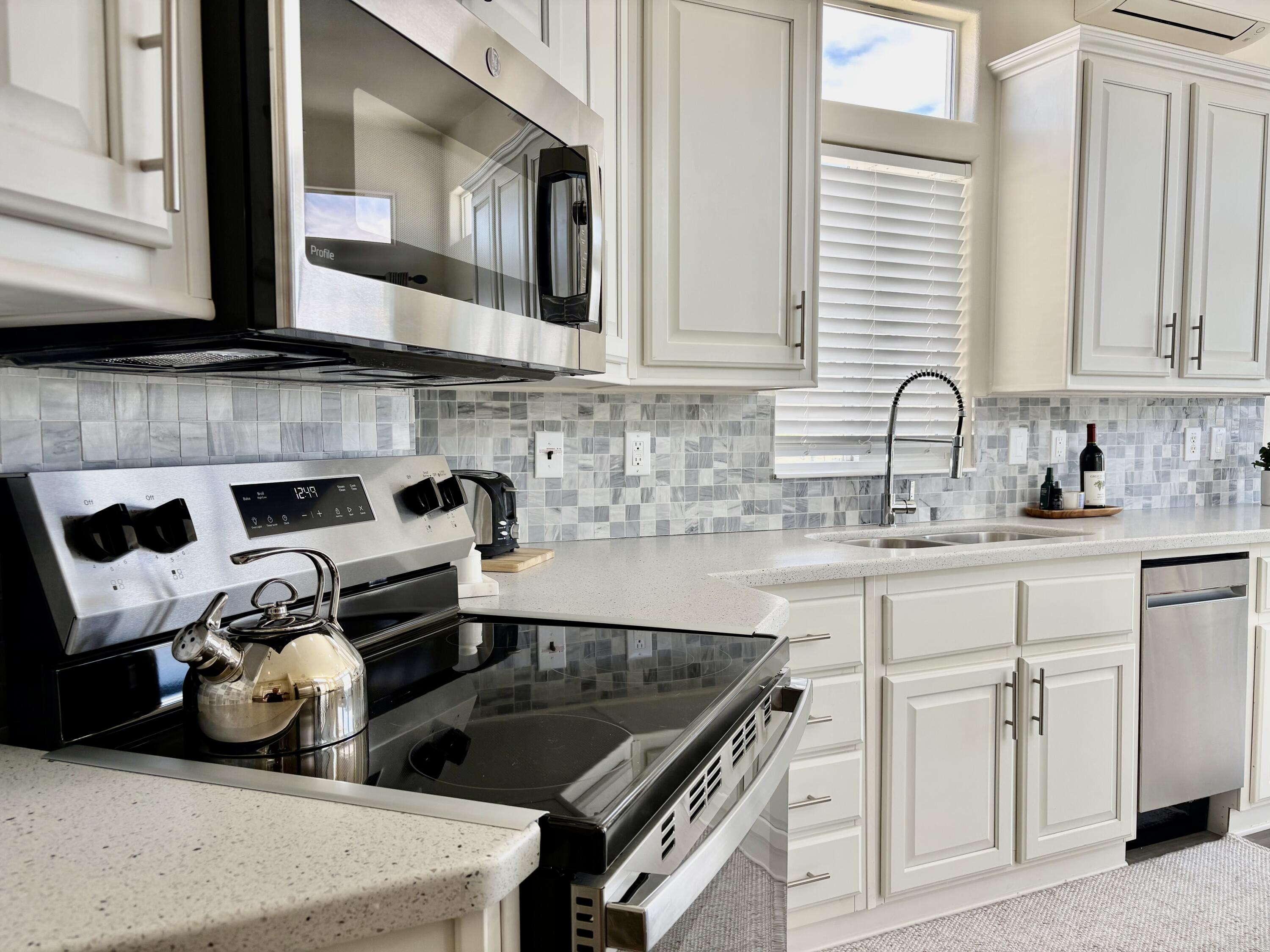70200 Dillon Road, Unit 200 Desert Hot Springs, CA 92241 - Photo 10 of 31 a kitchen with stainless steel appliances granite countertop a stove a sink and a white cabinets