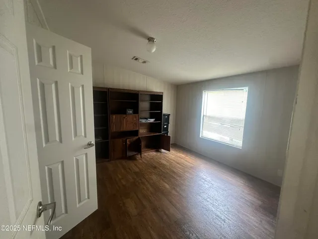 a bathroom with a granite countertop sink toilet and mirror