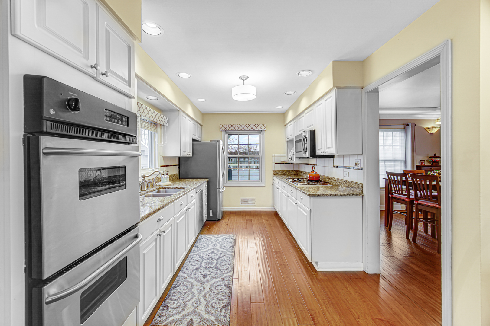 1910 Coventry Road New Lenox, IL 60451 - Photo 3 of 40 a kitchen with stainless steel appliances kitchen island granite countertop a refrigerator a stove top oven a sink dishwasher and white cabinets with wooden floor