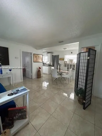 a living room with furniture a flat screen tv and a table