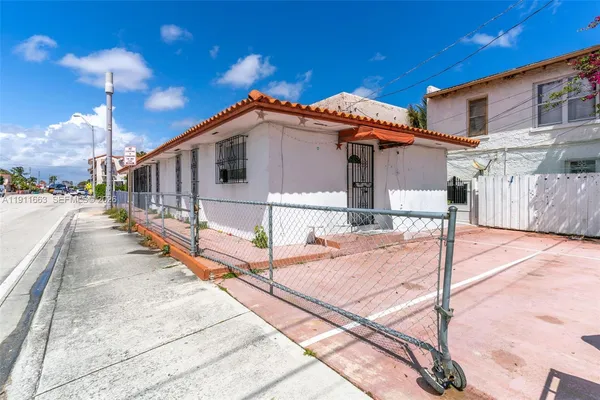 an aerial view of residential houses with outdoor space and parking