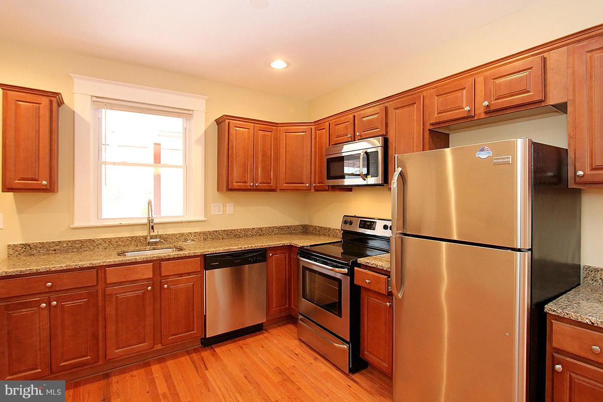 3106 Rueckert Avenue Baltimore, MD 21214 - Photo 9 of 29 a kitchen with stainless steel appliances granite countertop a refrigerator sink and wooden cabinets