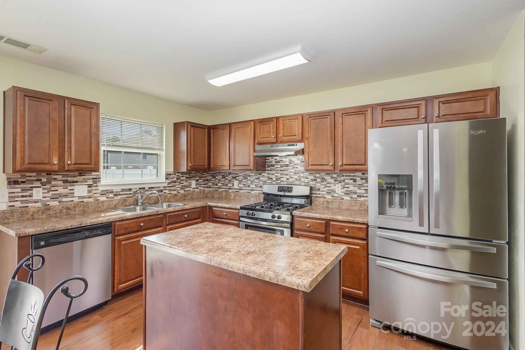 714 Waterlemon Way Monroe, NC 28110 - Photo 19 of 38 a kitchen with stainless steel appliances granite countertop a refrigerator stove and sink