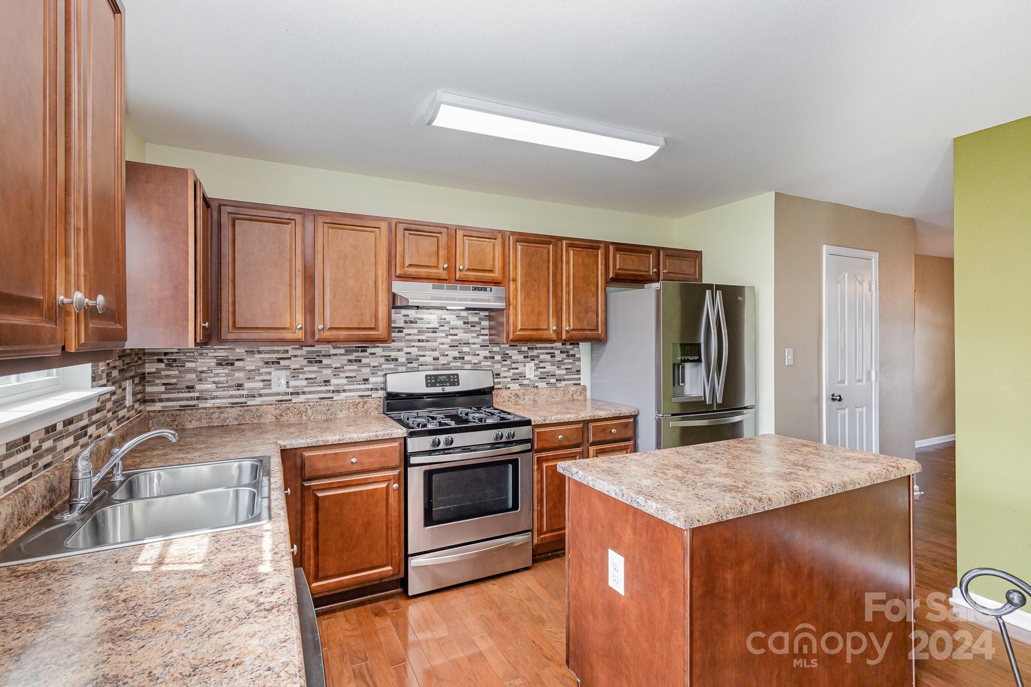 714 Waterlemon Way Monroe, NC 28110 - Photo 20 of 38 a kitchen with a stove and a refrigerator