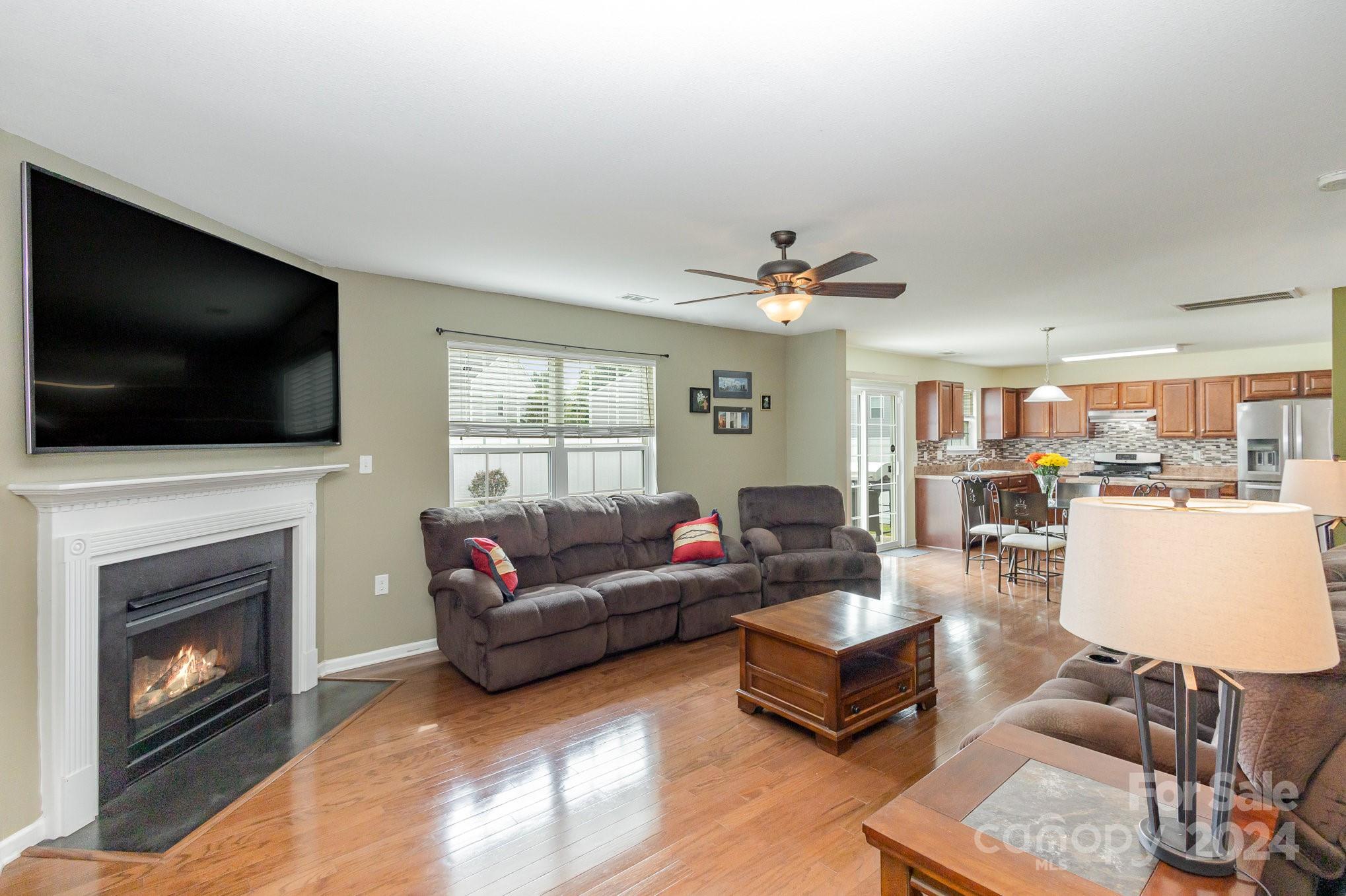 714 Waterlemon Way Monroe, NC 28110 - Photo 10 of 38 a living room with furniture a flat screen tv and a fireplace
