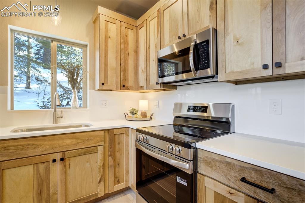 162 Kernite Lane Divide, CO 80814 - Photo 11 of 29 a kitchen with stainless steel appliances granite countertop white cabinets a stove a microwave and a refrigerator