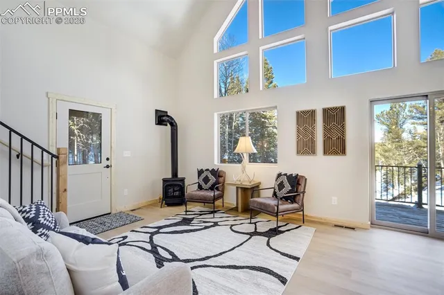 a dining room with furniture a rug and a floor to ceiling window