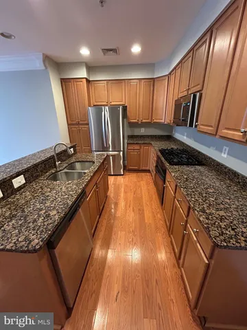 a kitchen with stainless steel appliances granite countertop a stove a sink and a refrigerator