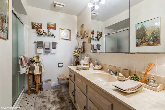 a bathroom with a granite countertop sink a toilet and a mirror