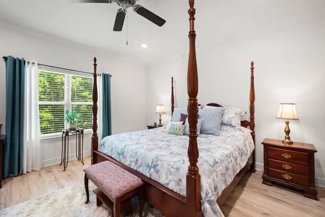 a bedroom with a bed wooden floor and a window