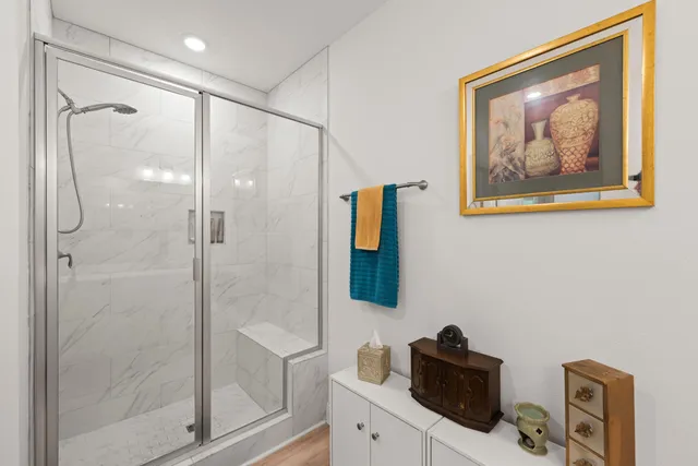 a bathroom with a painting on the wall and shower