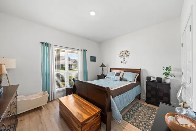 a bedroom with bed and wooden floor