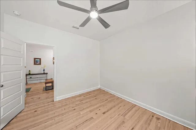 a view of empty room with wooden floor