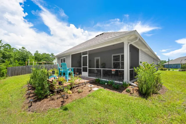 a view of a house with backyard sitting area and garden