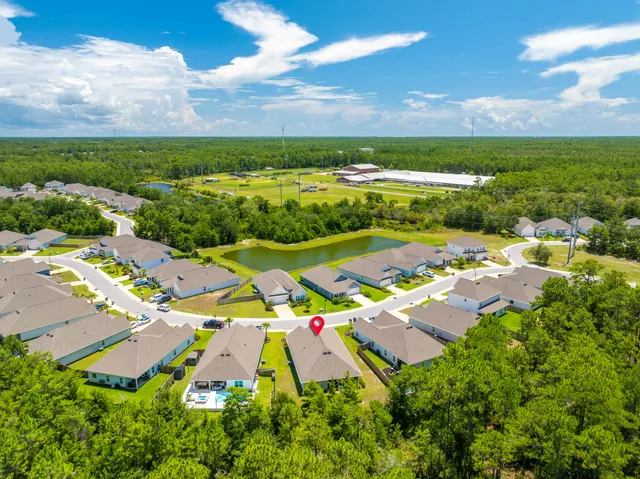 an aerial view of residential houses with outdoor space and swimming pool
