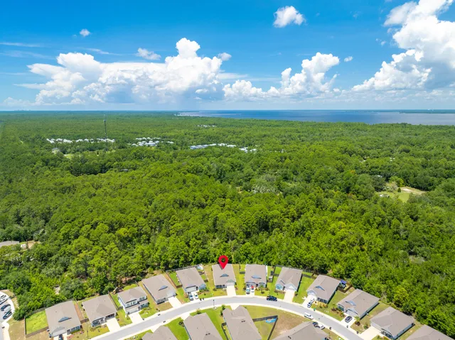 an aerial view of a house with a garden and lake view