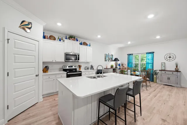 a kitchen with a sink white cabinets and white appliances