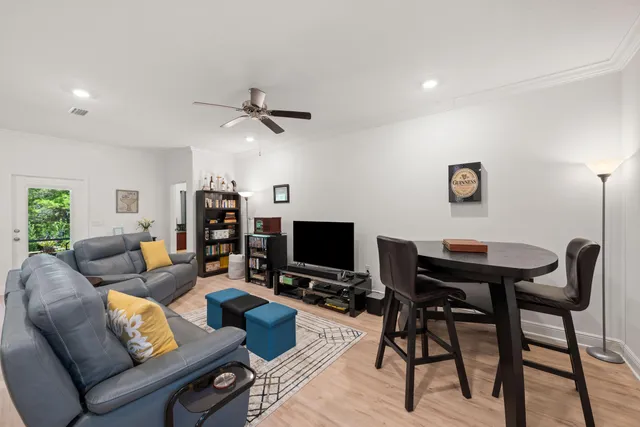 a living room with furniture a ceiling fan and a flat screen tv