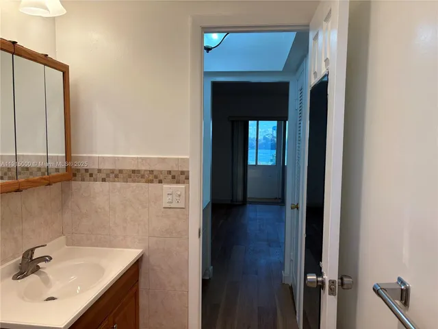 a view of a room with wooden floor and white walls