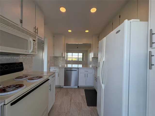 a kitchen with stainless steel appliances granite countertop a refrigerator stove and sink