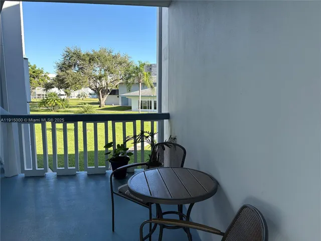 a view of a hallway with wooden floor and a potted plant