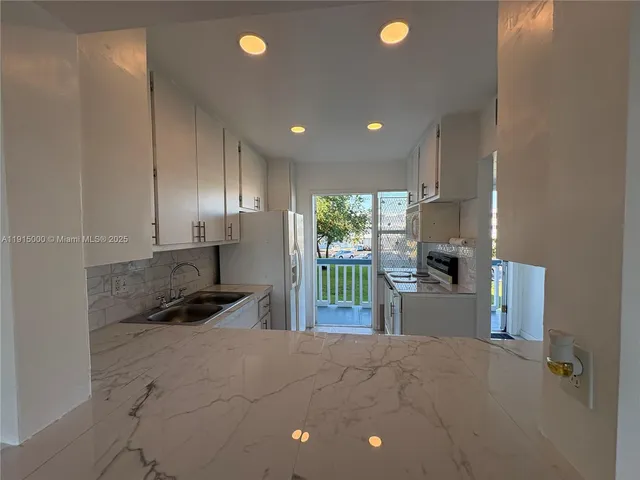 a kitchen with stainless steel appliances a stove a refrigerator a sink and a stove