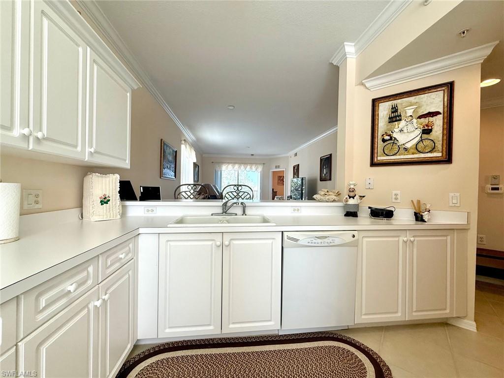 8450 Kingbird Loop, Unit 431 Estero, FL 33967 - Photo 12 of 47 Kitchen with white cabinets, white dishwasher, ornamental molding, light countertops, and light tile patterned floors