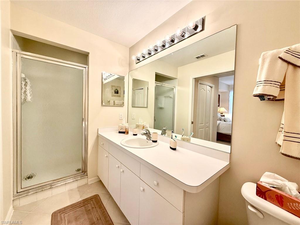 8450 Kingbird Loop, Unit 431 Estero, FL 33967 - Photo 18 of 47 Ensuite bathroom with a stall shower, vanity, and light tile patterned floors