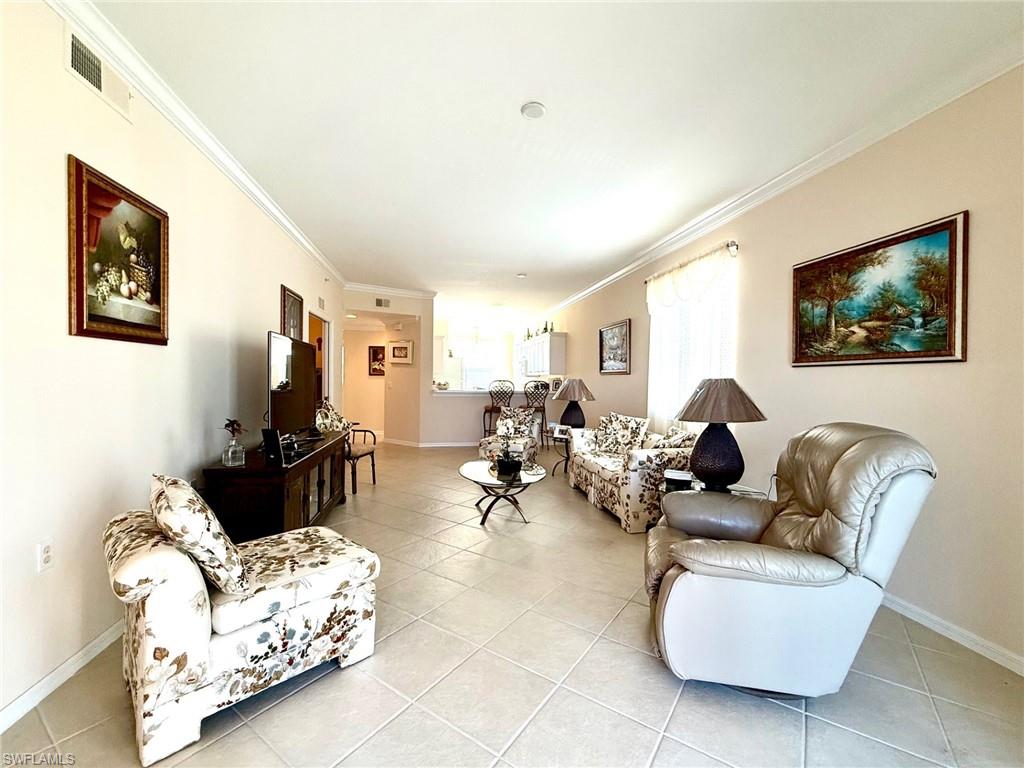 8450 Kingbird Loop, Unit 431 Estero, FL 33967 - Photo 26 of 47 Living room featuring crown molding and light tile patterned floors