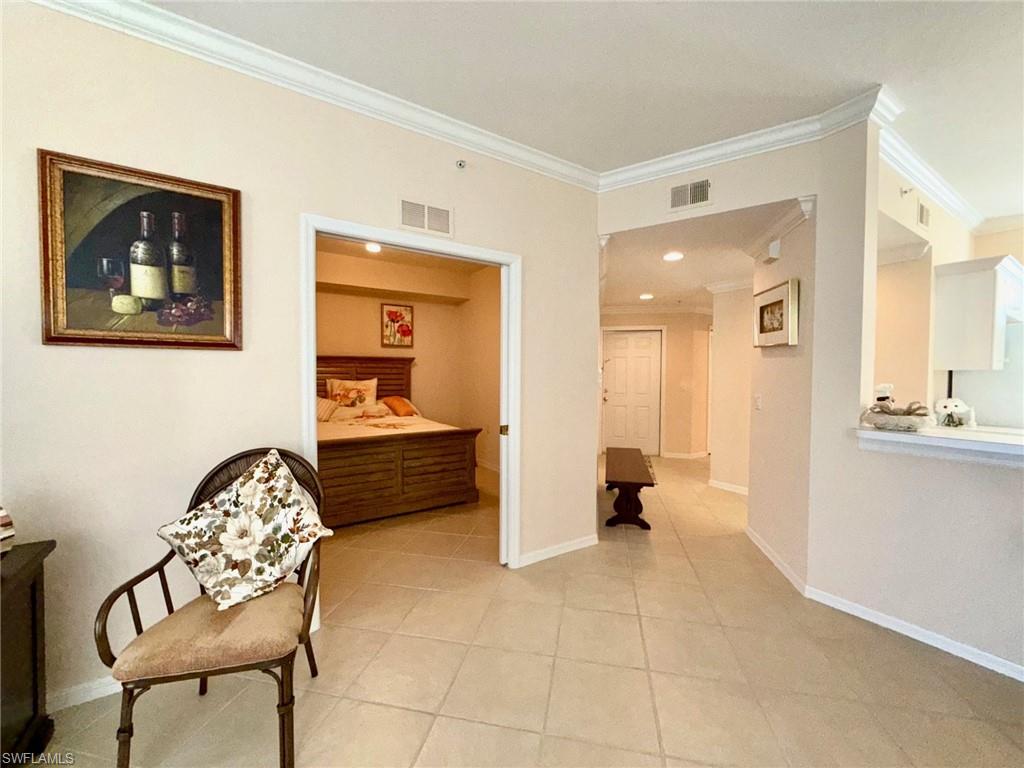 8450 Kingbird Loop, Unit 431 Estero, FL 33967 - Photo 32 of 47 Hallway with ornamental molding and light tile patterned floors