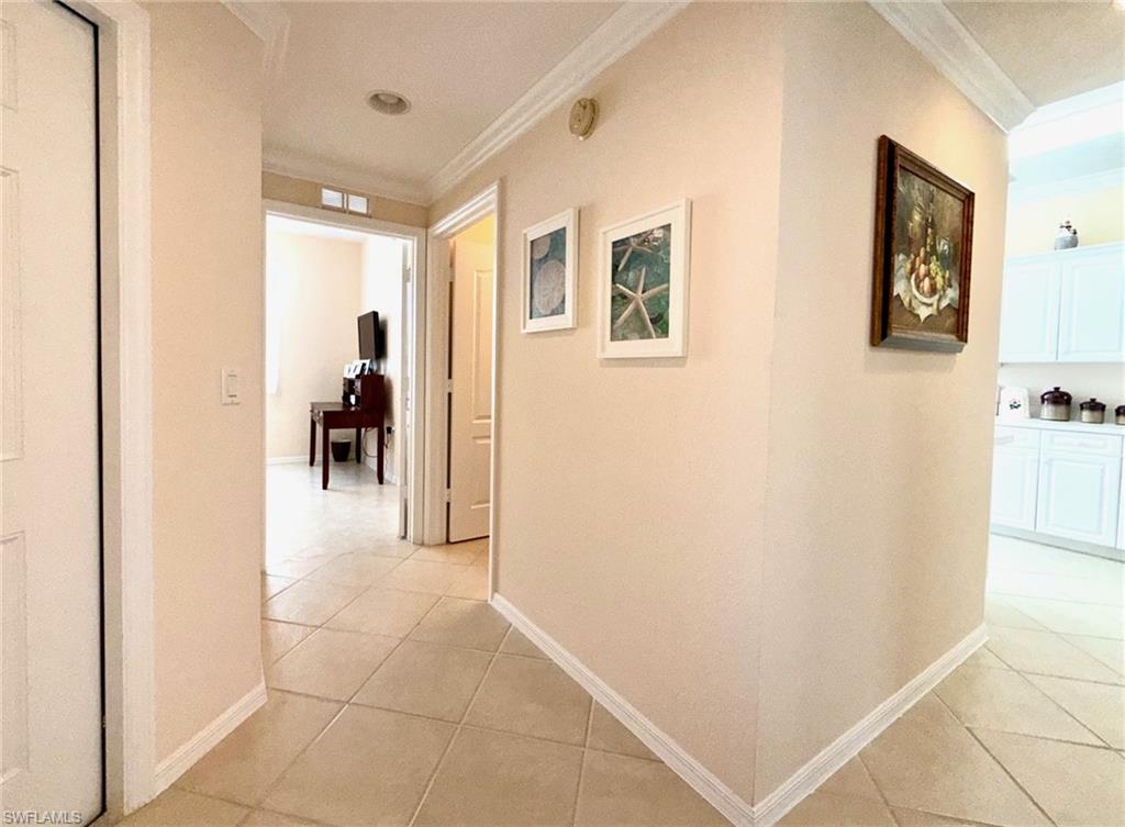 8450 Kingbird Loop, Unit 431 Estero, FL 33967 - Photo 35 of 47 Corridor featuring ornamental molding and light tile patterned flooring