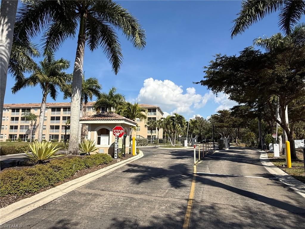 8450 Kingbird Loop, Unit 431 Estero, FL 33967 - Photo 46 of 47 View of asphalt road with traffic signs, a gated entry, and curbs