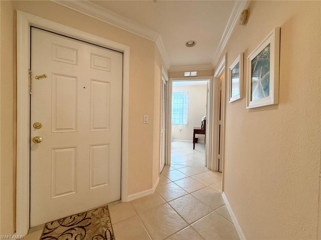 8450 Kingbird Loop, Unit 431 Estero, FL 33967 - Photo 7 of 47 Hall featuring ornamental molding and light tile patterned flooring