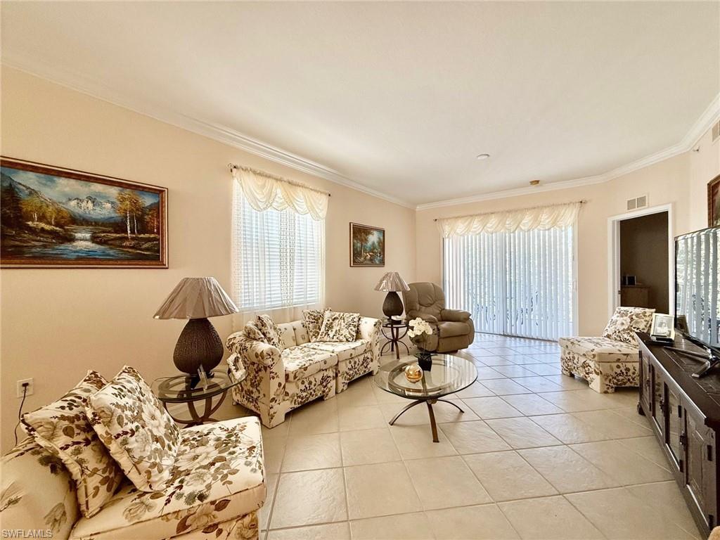 8450 Kingbird Loop, Unit 431 Estero, FL 33967 - Photo 8 of 47 Living room with crown molding and light tile patterned flooring