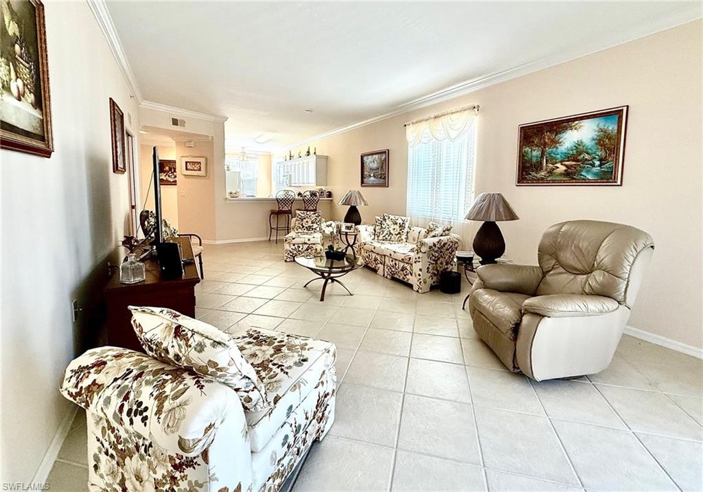 8450 Kingbird Loop, Unit 431 Estero, FL 33967 - Photo 9 of 47 Living area featuring light tile patterned flooring and crown molding