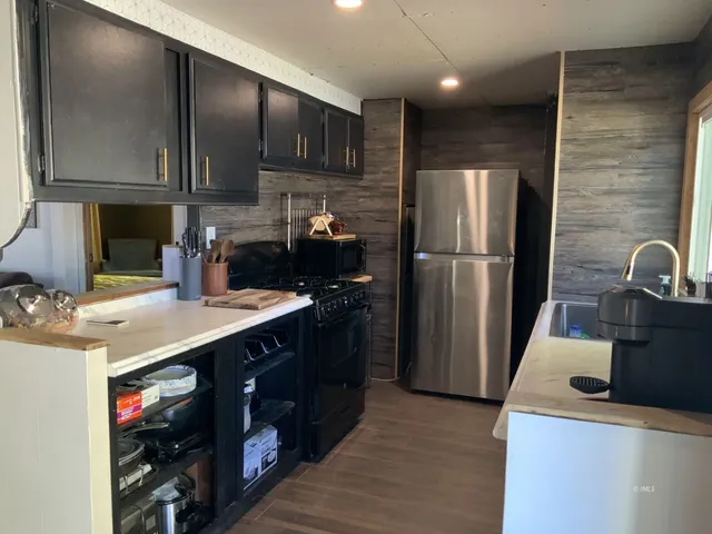 a kitchen with a sink a refrigerator and cabinets