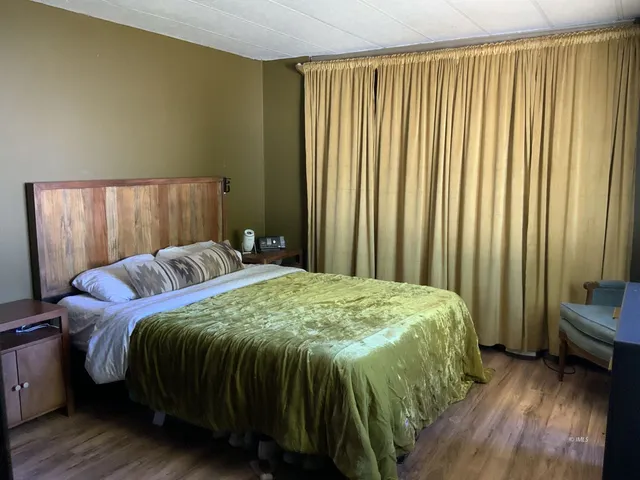 a bed sitting in a spacious bedroom next to a window